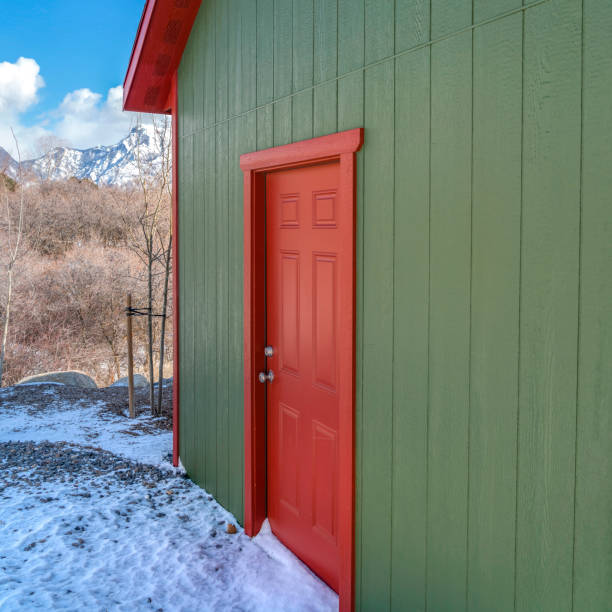 istock Clear Square Storage shed against trees and snow capped mountain under cloudy blue sky 1150130909