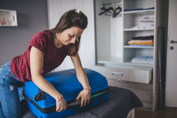 istock Young woman over-packed her suitcase 1150135754