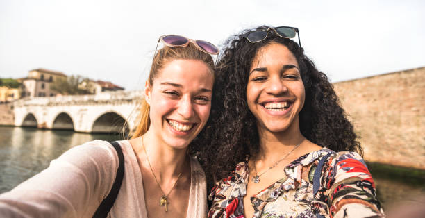 istock Multicultural girlfriends taking selfie having fun together - Friendship concept with happy girls at summer city vacation - Millenial lifestyle with female best friends women - Warm day filter tone 1150137577