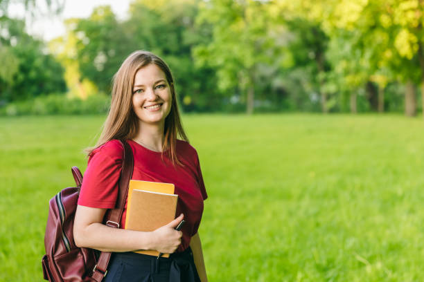 istock Happy student girl with notes and backpack. Entering the university, starting school in September 1150143977