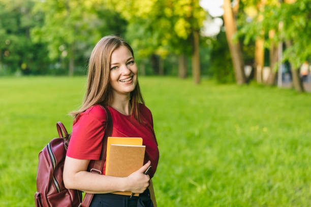 istock Happy student girl with notes and backpack. Entering the university, starting school in September 1150144008