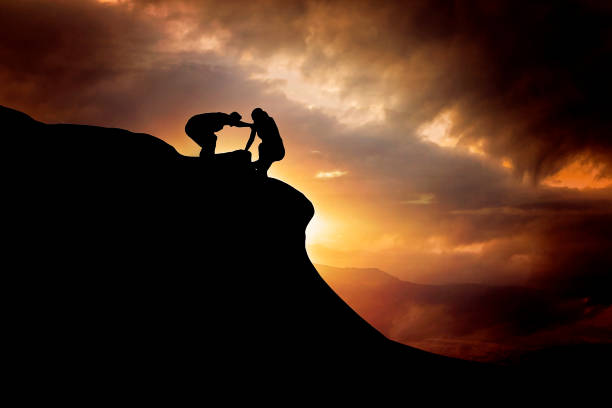 istock Teamwork couple helping hand trust on mountain peak. 1150147541