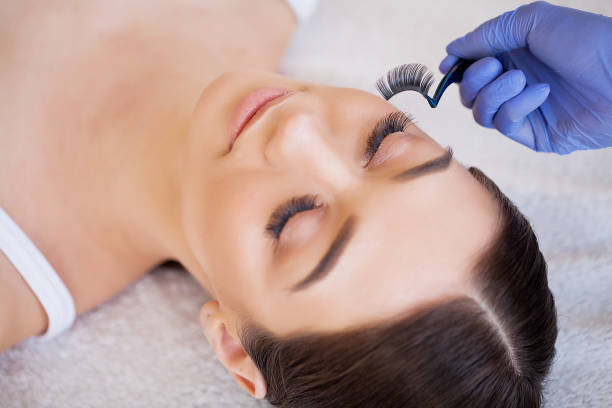istock Eyelashes extensions. Fake Eyelashes. Eyelash Extension Procedure. Professional stylist lengthening female lashes. Master and a client in a beauty salon 1150164225