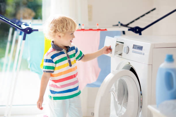 istock Child in laundry room with washing machine 1150164912