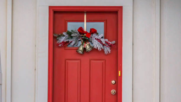 istock Clear Panorama Front door with glass panel and holiday decoration against a ribbed white wall 1150167330