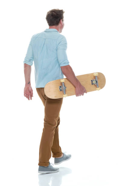 istock Casual well dressed man walking with a skateboard 1150167379