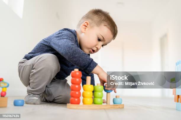 Kleiner Junge Der Mit Wenig Holzspielzeug Zu Hause Auf Dem Boden Lernt Farben Und Zählen Stockfoto und mehr Bilder von Kind
