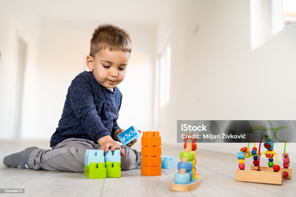 Kleiner Junge, der mit kleinen Backsteinspielzeug zu Hause auf dem Boden spielt, hat Spaß - Lizenzfrei Aktivitäten und Sport Stock-Foto