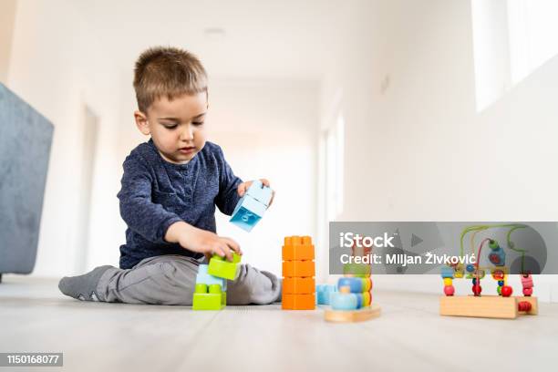 Kleiner Junge Der Mit Kleinen Backsteinspielzeug Zu Hause Auf Dem Boden Spielt Stockfoto und mehr Bilder von Bauen