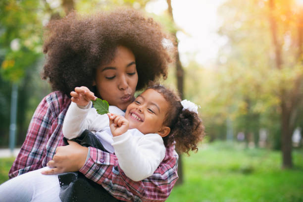 mère afro-américaine et sa fille. - mothers day mother kissing child photos et images de collection