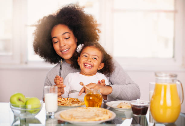 istock African-American young mother and daughter having breakfast 1150180500