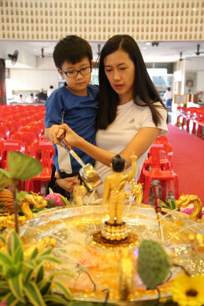 Wesak Day Celebration KUALA LUMPUR, MALAYSIA - 19 MAY 2019: Buddhist devotees visit Wisma Buddhist at Old Klang Road to celebrate Wesak Day. Volunteers and visitors' schedules are packed with vegetarian meals preparation, flower offerings, candle lighting, Little Buddha bathing and prayers chanting. happy vesak day stock pictures, royalty-free photos & images