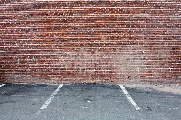 Photo of Brick Wall And Empty Parking Space