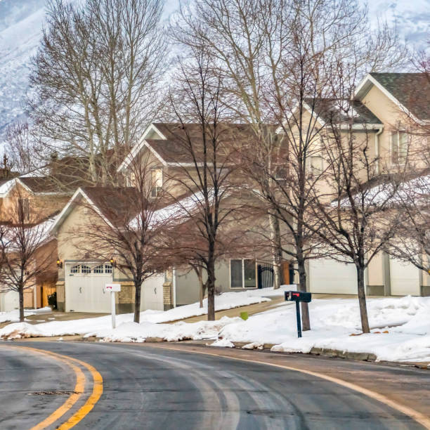 istock Square Road passing along beautiful homes with snow covered lawns in winter 1150186027