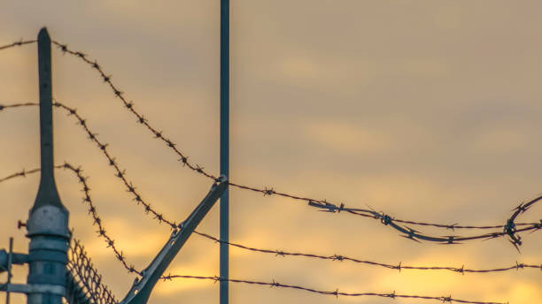 istock Panorama Chain link fence with barbed wire securing a Power Plant in Utah Valley 1150188635
