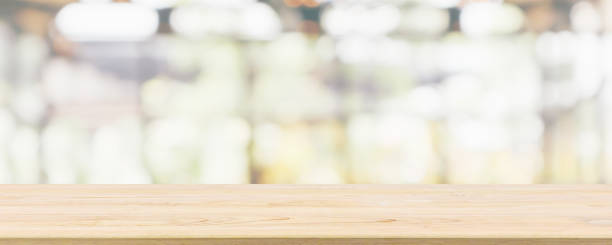 istock Empty wooden table top with cafe restaurant or coffee shop window interior abstract blur defocused with bokeh light background for montage product display 1150189423