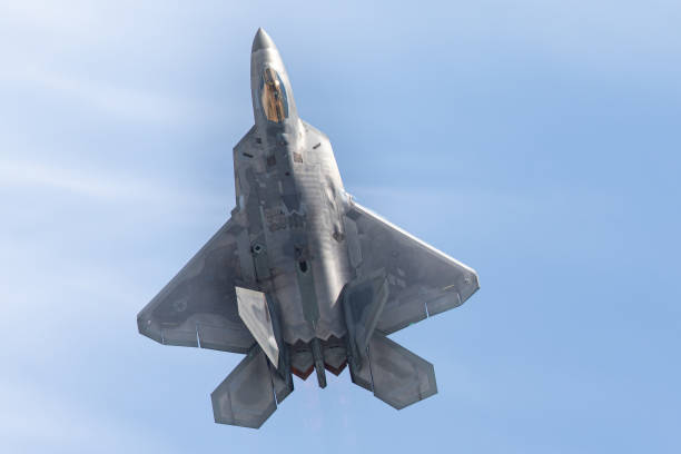 istock F-22 Raptor in beautiful light against clouds, with afterburners on 1150189615