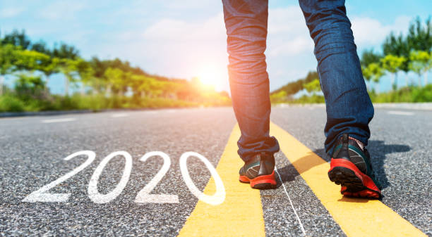 istock Man walking on the road with writing Number 2020 1150189677