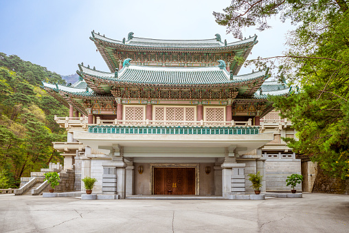 A stone archway in Ngong Ping Village. In the background the Tian Tan Buddha Statue. Lantau Island. Hong Kong.