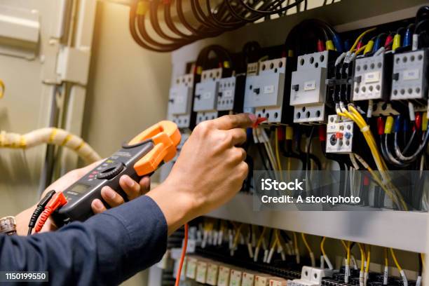 Electrician Engineer Work Tester Measuring Voltage And Current Of Power Electric Line In Electical Cabinet Control Stock Photo - Download Image Now
