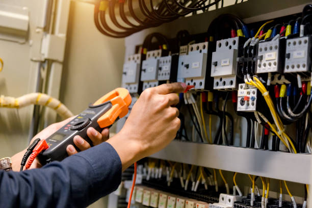 elektryk inżynier tester pracy pomiaru napięcia i prądu linii elektrycznej w elektoracie kontroli szafy. - engineer repairman manual worker electrician zdjęcia i obrazy z banku zdjęć