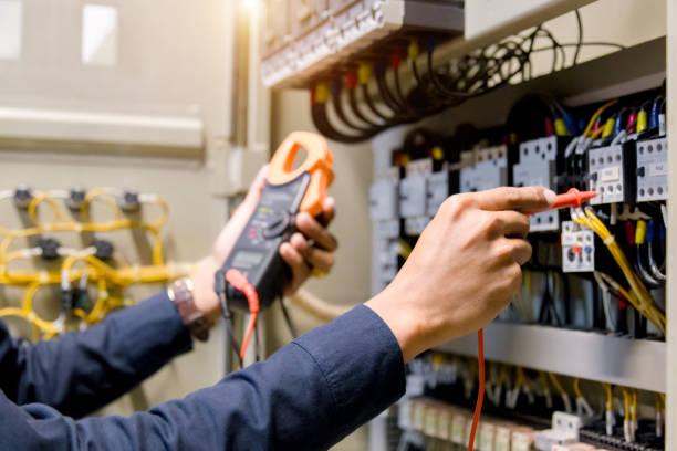 istock Electrician engineer work  tester measuring  voltage and current of power electric line in electical cabinet control. 1150199562