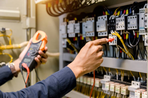 istock Electrician engineer work  tester measuring  voltage and current of power electric line in electical cabinet control. 1150199564