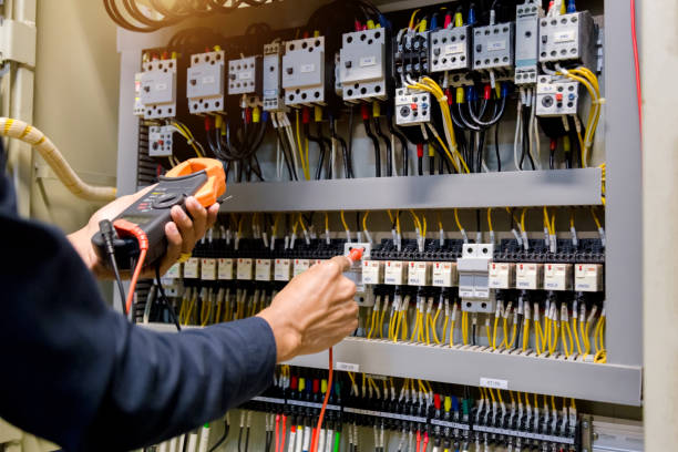 電気技師の仕事のテスターは、電化キャビネット制御の電力線の電圧と電流を測定します。 - power line electrician electricity manual worker ストックフォトと画像
