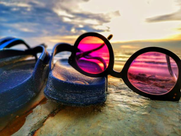 istock Beautiful sunset view with flip-flop and sunglasses on beach background. 1150199709