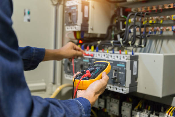 Electrician engineer work  tester measuring  voltage and current of power electric line in electical cabinet control. stock photo