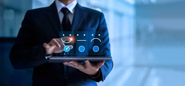 hombre de negocios tocando y dibujando sonrisa emoticono cara en la tableta, mente de servicio. fondo azul. concepto de servicio al cliente. - adulation fotografías e imágenes de stock