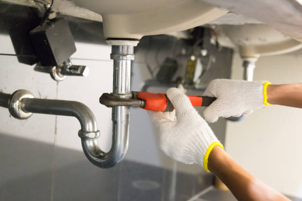istock Plumber fixing white sink pipe with adjustable wrench. 1150199899