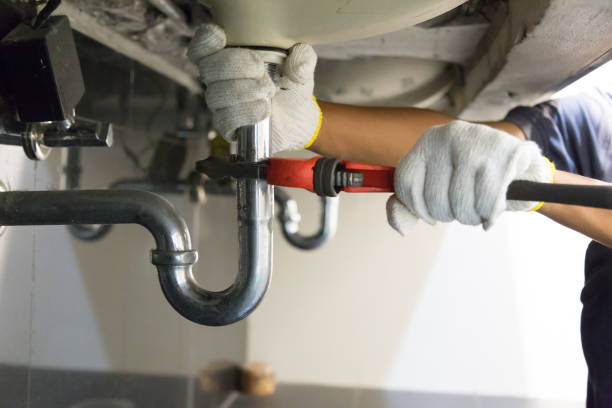 plumber fixing white sink pipe with adjustable wrench. - sink imagens e fotografias de stock