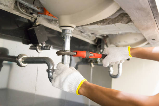 istock Plumber fixing white sink pipe with adjustable wrench. 1150199963