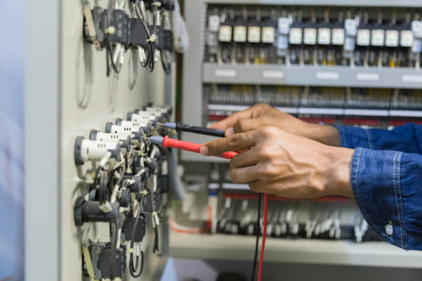 istock Electrician engineer work  tester measuring  voltage and current of power electric line in electical cabinet control. 1150200040