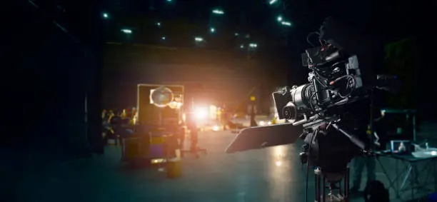 Photo of Behind the scenes of making of movie and TV commercial. Camera of movie and video production. Film Crew. B-roll, and crew team in studio and set on dark background