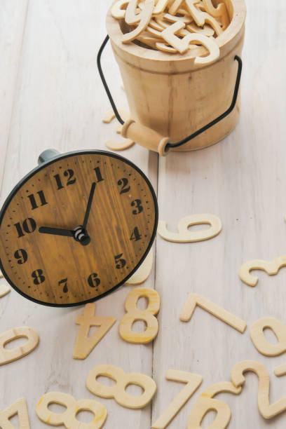 istock Conceptual clock and numbers in small wooden barrels 1150202359