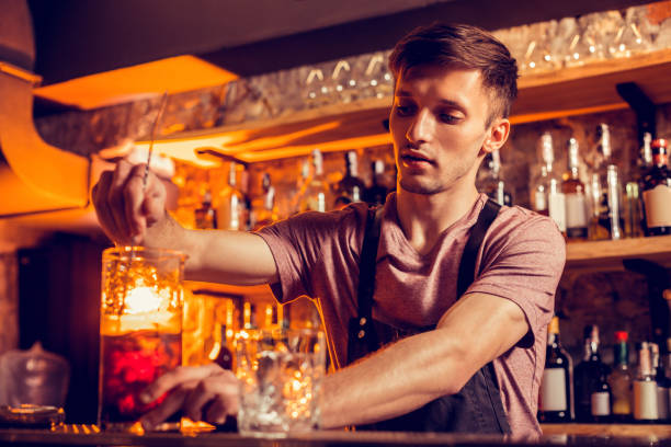 istock Bartender wearing black apron finishing making cocktail 1150202400