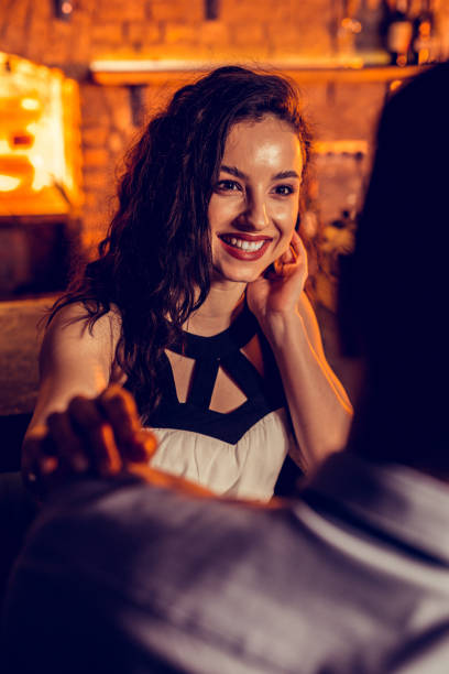 istock Beaming girlfriend talking to her man spending night in bar 1150202408