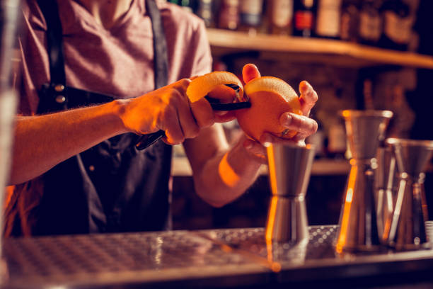 istock Barman wearing uniform peeling orange for cocktail 1150202495