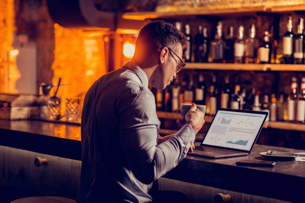 istock Businessman owning bar working on laptop and drinking coffee 1150202540