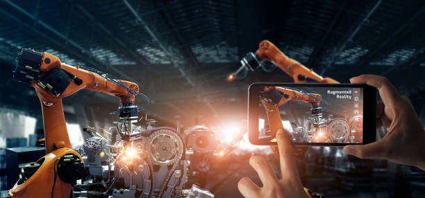 istock Augmented reality industry concept. Hand holding mobile smartphone use AR application to check and control welding robotics automatic arms machine in intelligent factory automotive industrial with monitoring system software.Digital manufacturing operation 1150204840