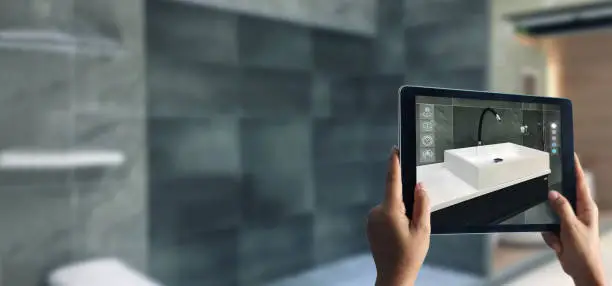 Augmented Reality bathroom planning. Sanitary ware. Hand holding digital tablet in real home background, AR application. A new way to experience products.