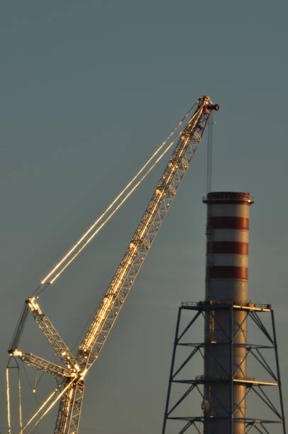 istock Power plant. Crane at a construction site. Chimney and smoke 1150219396