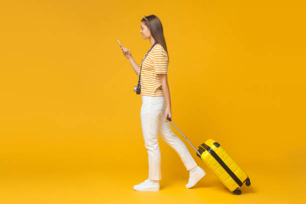 pełnowymiarowy portret europejskiej dziewczyny odizolowanej na żółtym tle spaceru z walizką do podróży - telephone child isolated on white elegance zdjęcia i obrazy z banku zdjęć