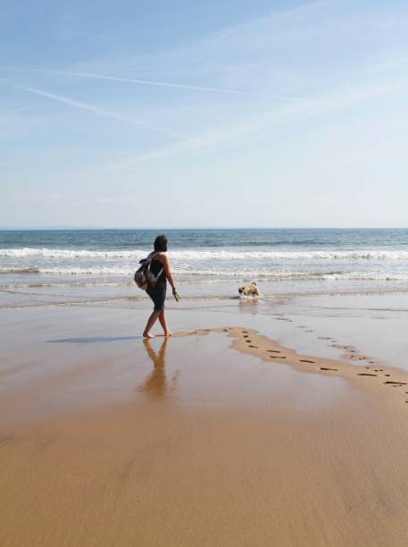 istock woman and dog on beach 1150232514