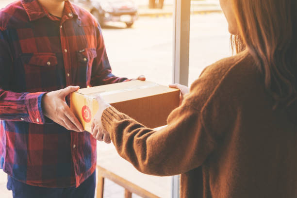 istock woman receiving parcel box from delivery man 1150233938