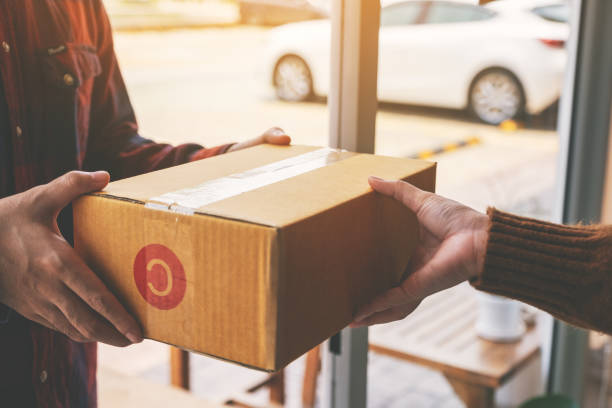 istock woman receiving parcel box from delivery man 1150234053