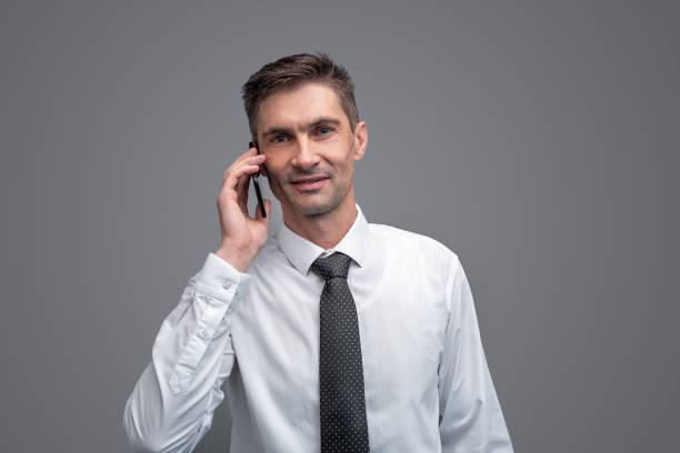 istock Businessman speaking on smartphone and looking at camera 1150240082