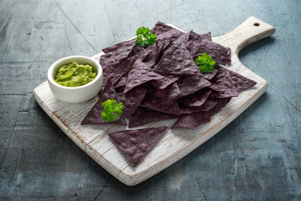 istock Blue corn Organic tortilla chips with Guacamole on white wooden board 1150245140